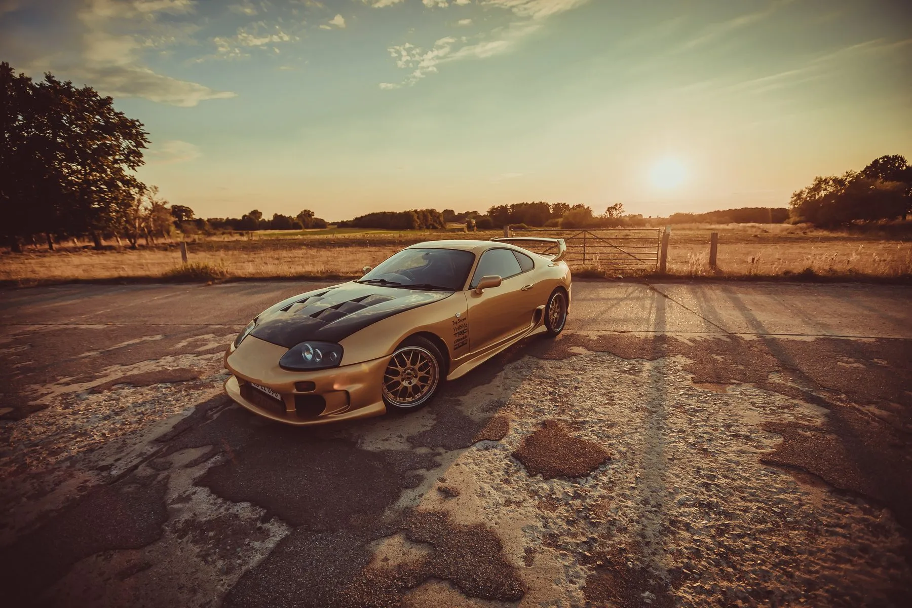 Toyota Supra A80 modificado de color dorado en un circuito